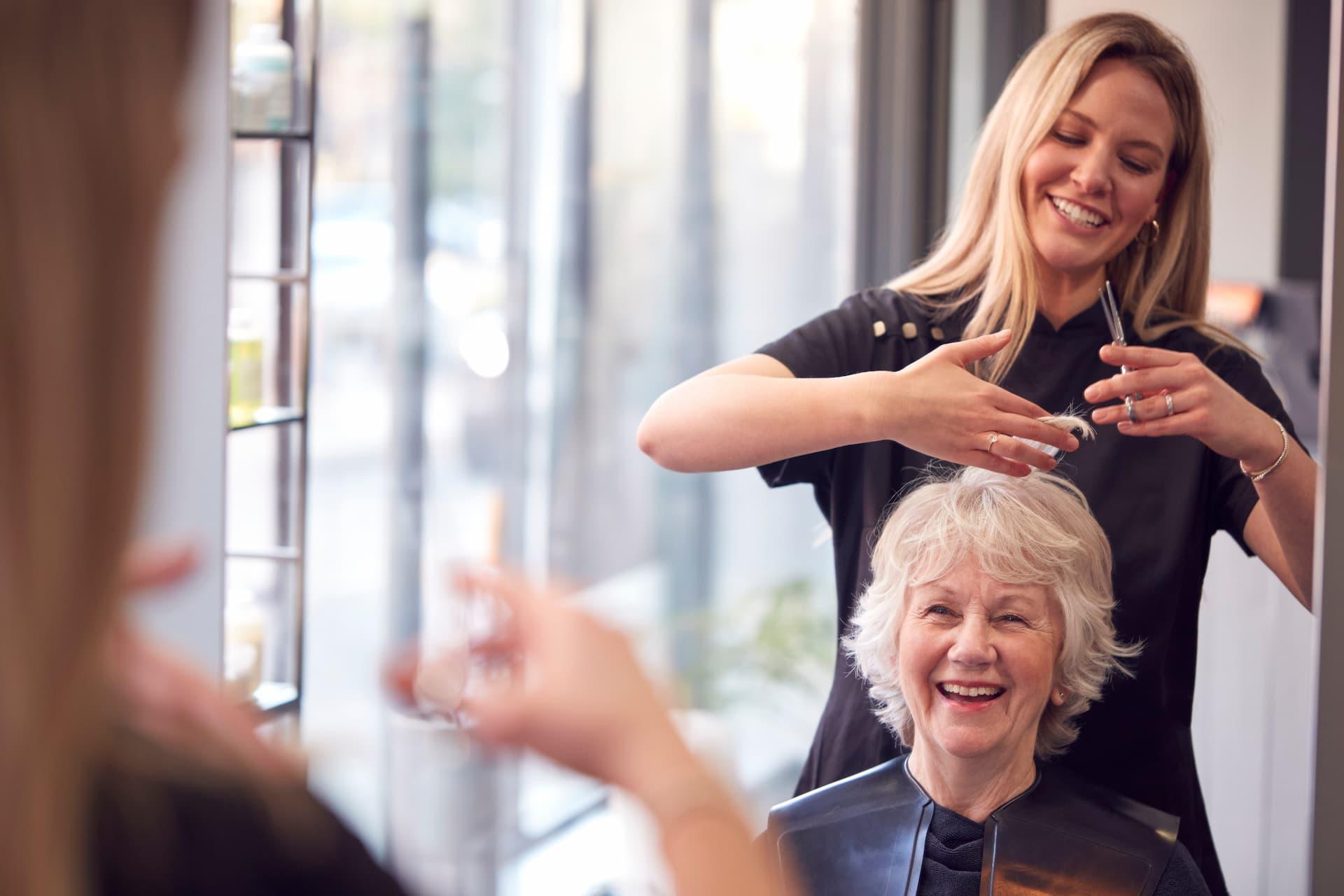 Coiffeuse coupant les cheveux d'une femme - création d'entreprise